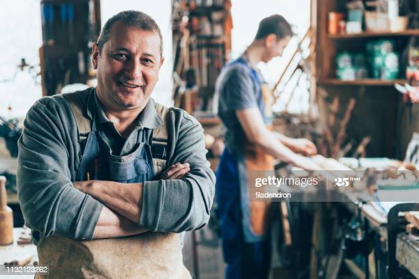 Portrait of Craftsman crossed arms in carpentry workshop Portrait of Craftsman crossed arms in carpentry workshop